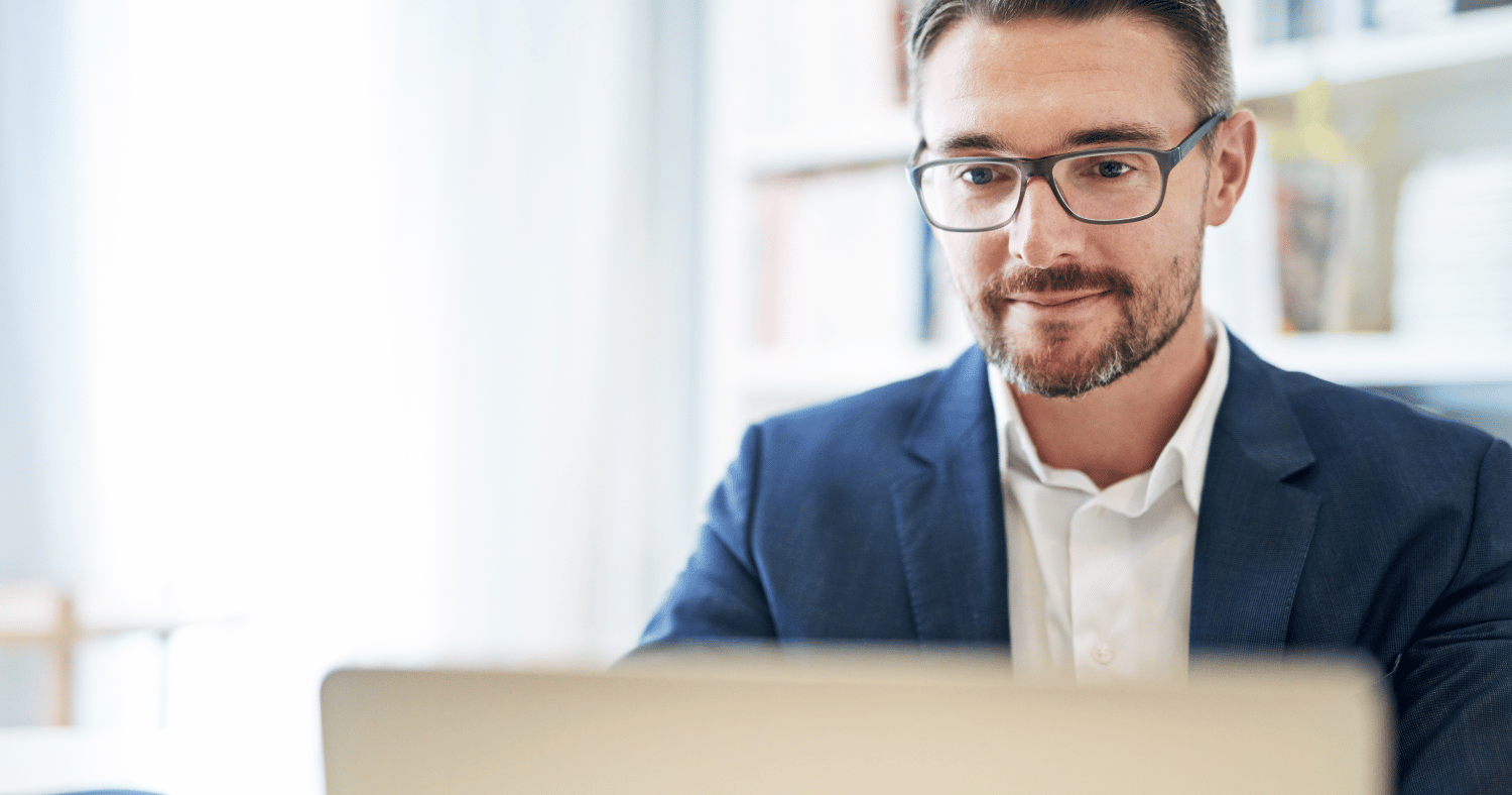 Man encrypting email using laptop in office wearing suit