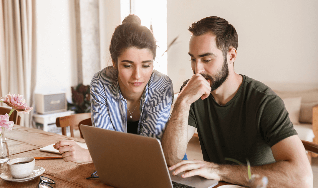 Couple looking at potentially sensitive document on their laptop