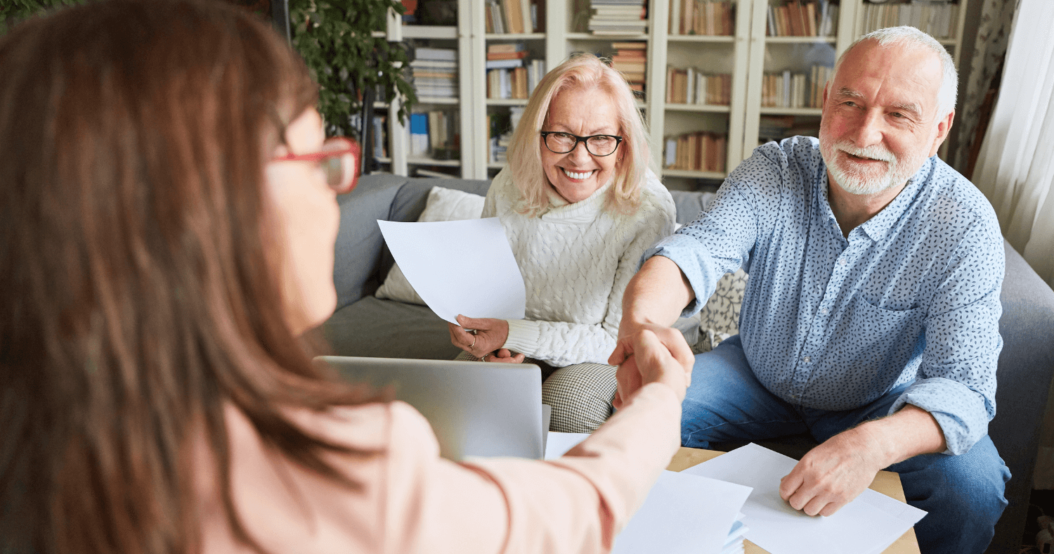 Financial adviser shaking hands with her senior clients