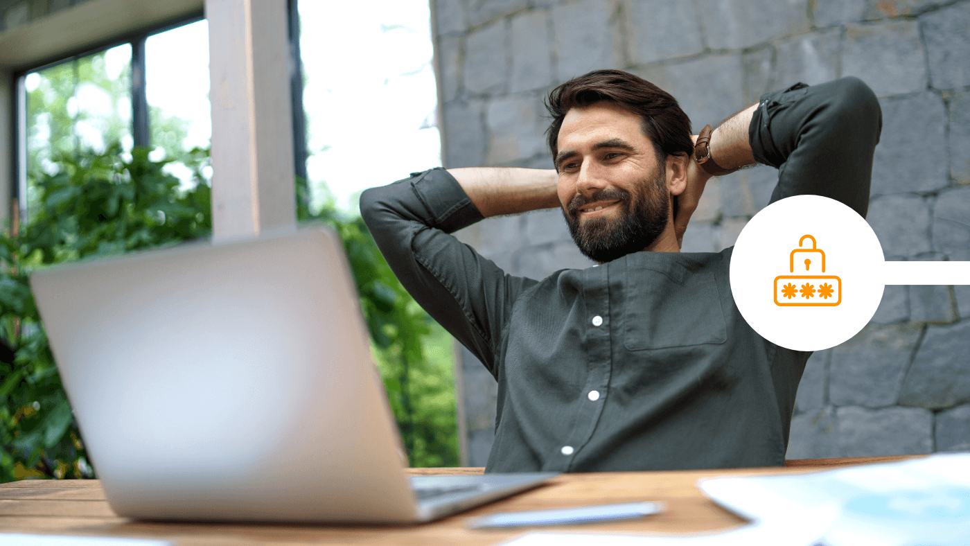 Male professional smiling and looking at laptop on desk