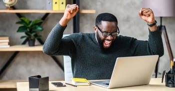 Man successfully recalling an email in office with laptop