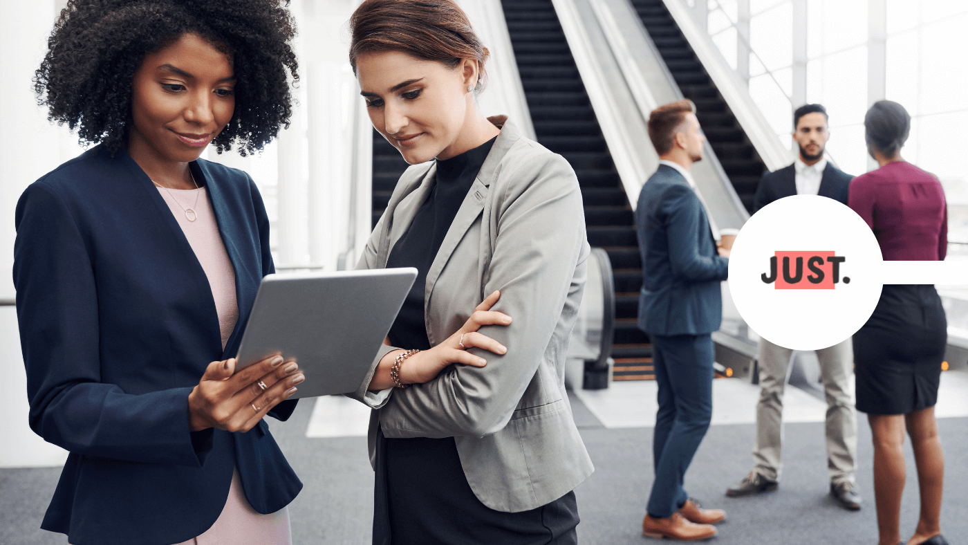 Professionals in corporate office looking at smart tablet together