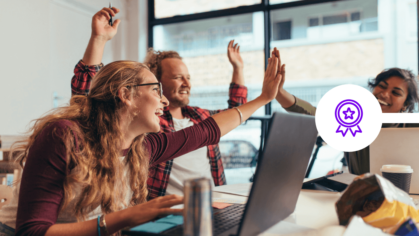 Team high five in office to celebrate award wins