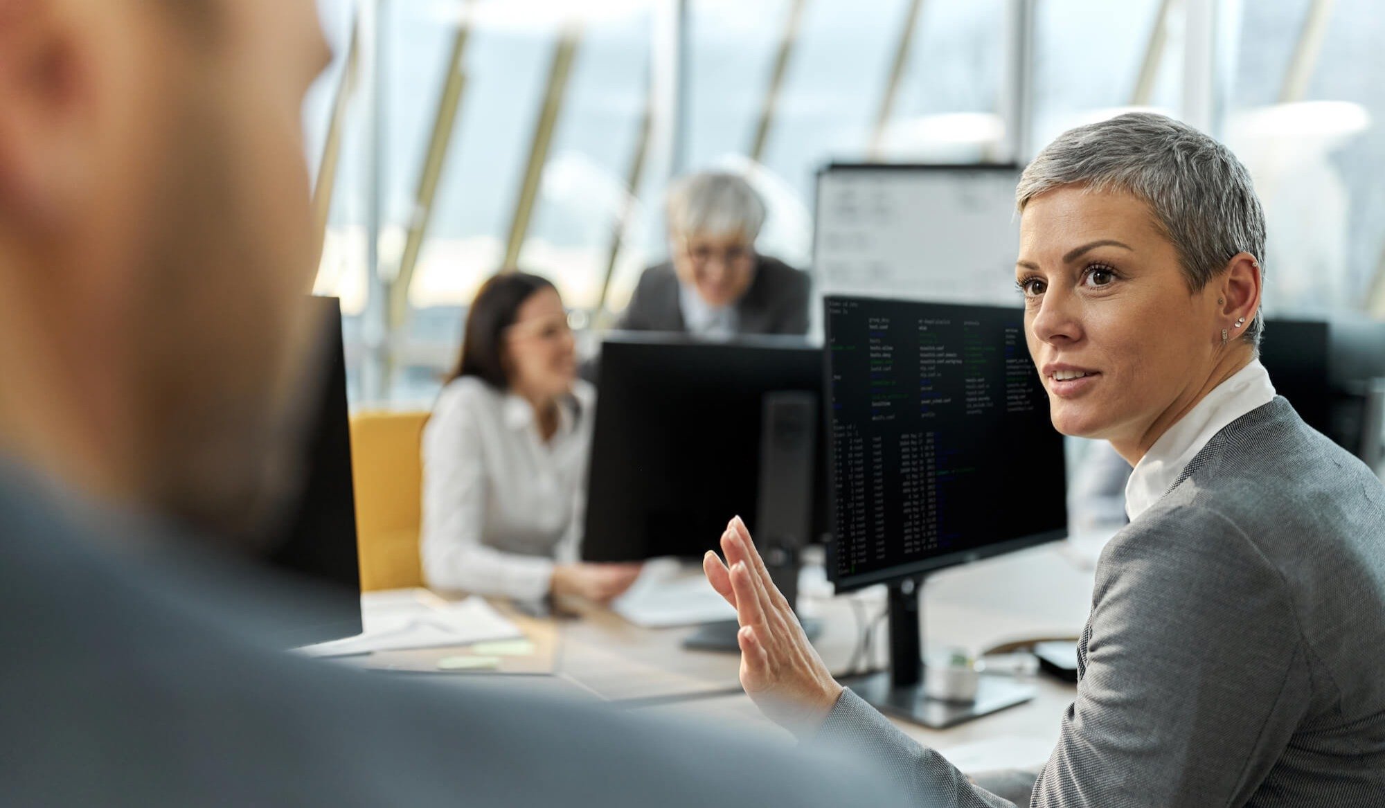 Woman speaking to colleague in office about email security