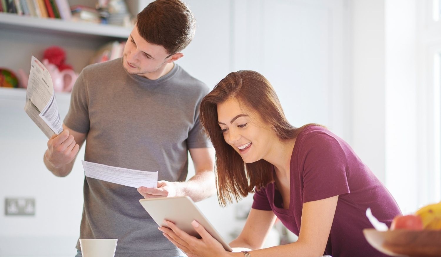 couple in kitchen doing their finances on secure device