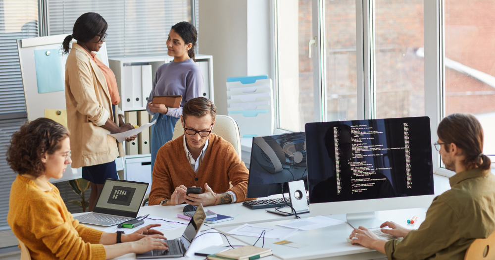 Development team working in office on desktop computers