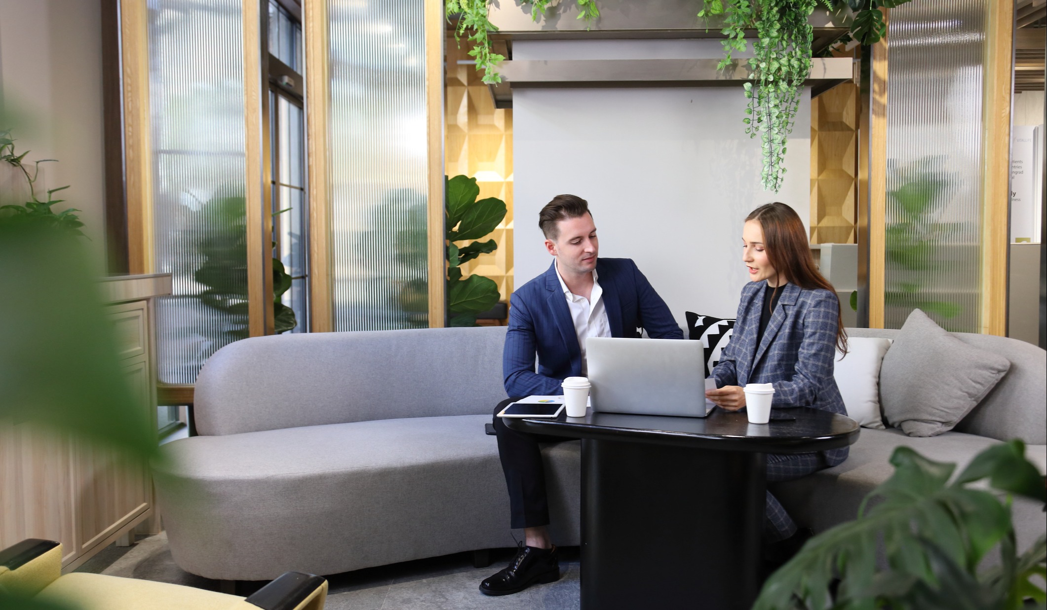 man and woman looking at laptop in office