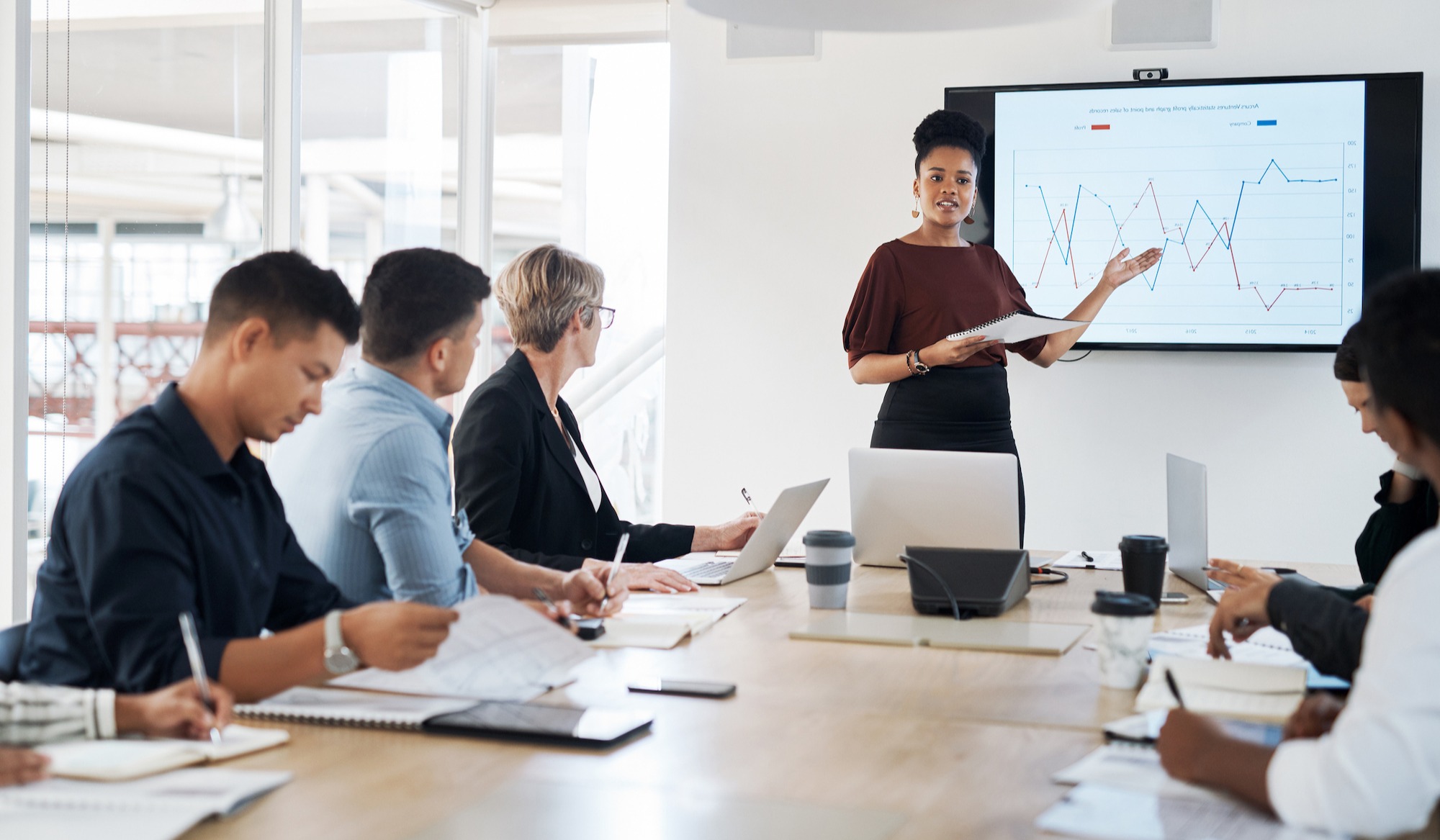 woman pointing to graph in board room